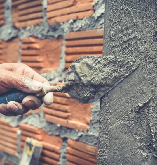 bricklaying construction worker building brick wall 1 scaled e1759317104415